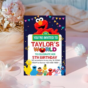 May include: A colorful birthday invitation featuring Elmo from Sesame Street. The invitation has the text "You're Invited to Taylor's World" and "5th Birthday". The invitation includes the address and RSVP information.