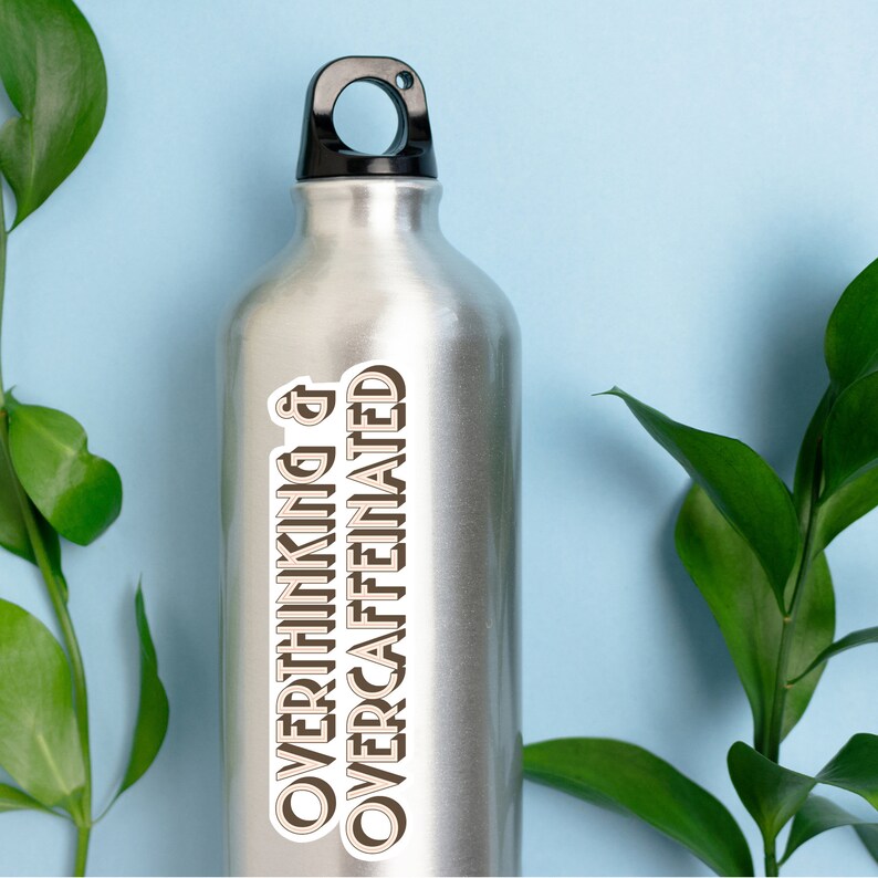 May include: A silver water bottle with a black lid and a white sticker that says "Overthinking & Overcaffeinated" in brown text.