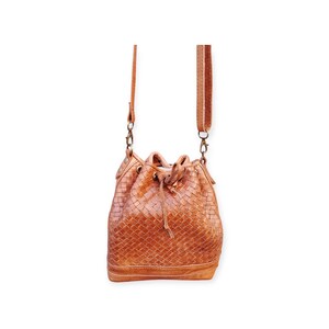 Puede incluir: Bolso tipo cubo de cuero trenzado marr&oacute;n. Cuenta con cierre de cord&oacute;n, correa ajustable y herrajes met&aacute;licos. El dise&ntilde;o del bolso incluye un patr&oacute;n tejido, que a&ntilde;ade textura e inter&eacute;s visual al accesorio.