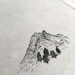 Puede incluir: Dibujo a pluma en blanco y negro de una cordillera con algunos &aacute;rboles. La obra de arte est&aacute; realizada sobre un papel texturizado blanquecino. La monta&ntilde;a tiene un pico irregular y sombreado detallado.