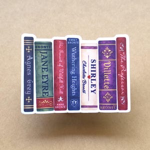 May include: A sticker featuring a row of seven classic book spines by the Brontë sisters. The titles include Agnes Grey, Jane Eyre, The Tenant of Wildfell Hall, Wuthering Heights, Shirley, Villette, and The Professor, displayed in various colours.