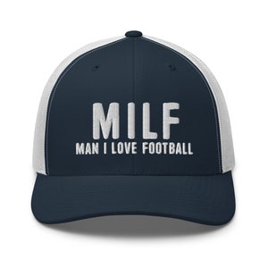 May include: A navy blue and white trucker hat with the text "MILF MAN I LOVE FOOTBALL" embroidered in white.