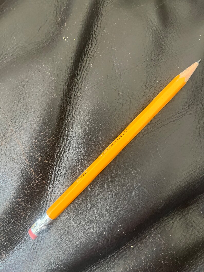 May include: A yellow pencil with a red eraser and the text "UNI-BALL" printed on the side.
