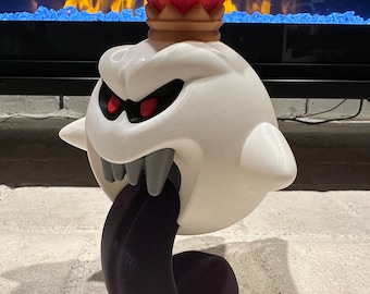 May include: A white King Boo figurine with a red and gold crown. The figurine has a large, toothy mouth and a long, black tongue.