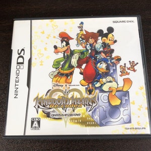 Peut inclure: Une boîte de jeu Nintendo DS pour Kingdom Hearts Re:coded. La couverture présente Mickey Mouse, Donald Duck, Dingo et Sora de la série Kingdom Hearts. Le jeu est classé A par le système de classification CERO.
