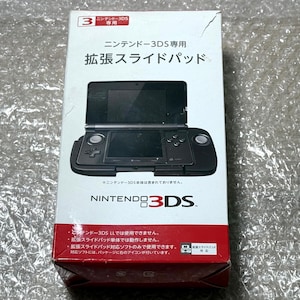 Puede incluir: Un accesorio de deslizamiento negro para la consola de juegos portátil Nintendo 3DS. El embalaje muestra el deslizamiento de la almohadilla conectado a la consola. El texto en el embalaje dice "Nintendo 3DS" y "Almohadilla de deslizamiento de expansión".