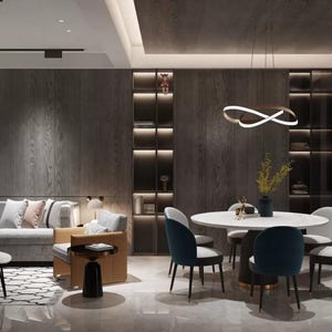 Puede incluir: Un salón y comedor modernos con una paleta de colores neutros. La sala de estar cuenta con un sofá gris con cojines decorativos, una mesa de centro y una alfombra estampada. El comedor tiene una mesa redonda con sillas azules. La habitación está bien iluminada.