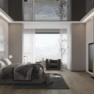 Op de afbeelding: Een moderne slaapkamer met een grijs bed, een grote flatscreen tv en een grijze fauteuil. De kamer heeft een groot raam met uitzicht op de skyline van een stad. Het plafond is zwart en reflecterend.