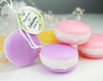 May include: A collection of colorful, macaron-shaped soaps in shades of pink, yellow, and purple. One soap is in a sheer bag with a tag that reads "Thank you for Celebrating with us."