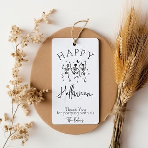 May include: White card with black text and illustrations. The text reads "Happy Halloween" with three skeletons dancing. The text continues "Thank You for partying with us The Bakers".