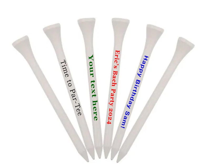 K&ouml;nnte beinhalten: F&uuml;nf wei&szlig;e Golf-Tees mit personalisierten Botschaften. Die Botschaften lauten "Happy Birthday Sam!" in Blau, "Eric's Bach Party 2024" in Rot, "Your text here" in Gr&uuml;n und "Time to Par-Tee" in Gr&uuml;n.