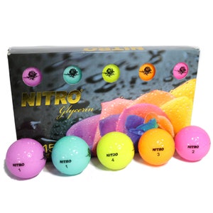 May include: A box of Nitro Glycerin golf balls with a colorful floral design. The box features the brand name in gold lettering. Six golf balls are visible, in pink, teal, yellow, and orange, each with a number and the Nitro logo.