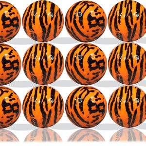 May include: Twelve orange and black golf balls with a tiger stripe pattern.