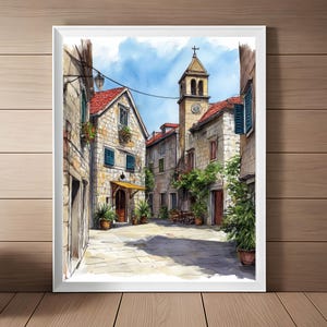 Puede incluir: Pintura a la acuarela de una escena de calle europea. Edificios con tejados de tejas rojas y muros de piedra bordean una calle adoquinada. Una torre de iglesia con un reloj y una cruz se alza al fondo. Plantas en macetas y contraventanas azules añaden color.