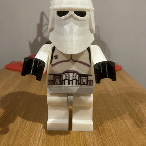 May include: White Lego minifigure of a Star Wars Stormtrooper with a black helmet and black hands.