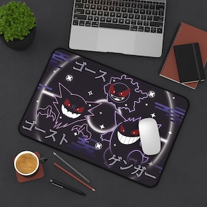 May include: Black rectangular mousepad with a cartoon ghost design in white and purple, featuring Japanese text. The design includes three ghost characters with red eyes and white teeth. A white computer mouse is on the mousepad.