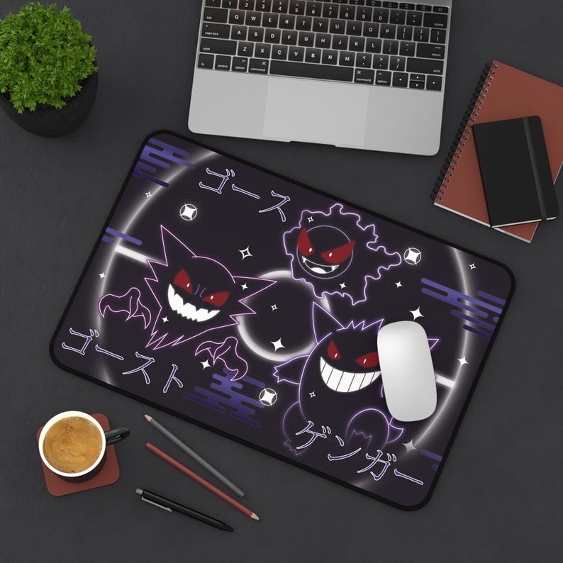 May include: Black rectangular mousepad with a cartoon ghost design in white and purple, featuring Japanese text. The design includes three ghost characters with red eyes and white teeth. A white computer mouse is on the mousepad.
