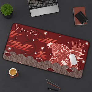 Könnte beinhalten: Rechteckiges rotes Mauspad mit einer stilisierten Illustration eines Wesens und japanischem Text. Das Design umfasst geometrische Formen, Wellen und Sterne. Eine weiße Maus liegt auf dem Pad.