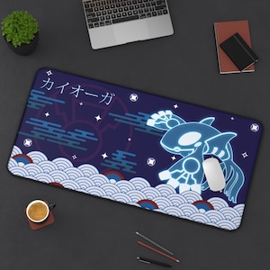 May include: A rectangular mousepad featuring a blue and white illustration of a Kyogre character with Japanese text. The design includes stylized waves and stars on a dark blue background. A white mouse rests on the pad.