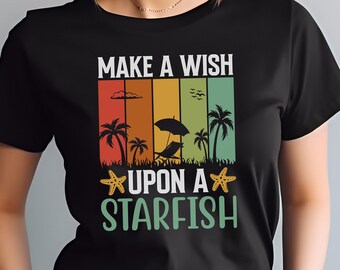 May include: Black t-shirt featuring a retro-style graphic that reads "Make a Wish Upon a Starfish". The graphic depicts a beach scene with palm trees, an umbrella, and a starfish.