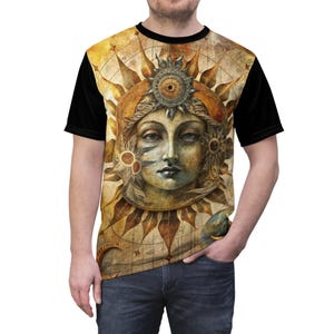May include: A t-shirt featuring a detailed illustration of a celestial figure with a sun-like halo. The design is predominantly in shades of gold, brown, and beige, with black sleeves. The artwork has a vintage, artistic style.