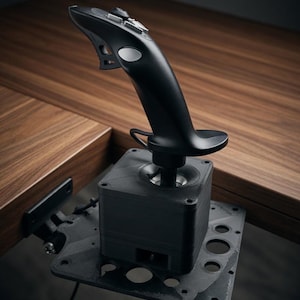 May include: Black joystick controller with buttons and a handle, mounted on a black base with a metal plate. The controller is designed for gaming or flight simulation, with a sleek, ergonomic design.