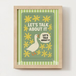 May include: A framed art print featuring a white goose with an open beak, surrounded by yellow flowers. The text "LET'S TALK ABOUT IT" is displayed in a speech bubble and above the goose. The background is green with a striped border.