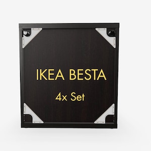 Può includere: Un set di mobili IKEA BESTA marrone scuro con la scritta "IKEA BESTA" in lettere dorate e "4x Set" sotto. L'armadio ha staffe angolari argentate.