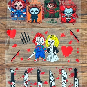 May include: A clear transfer sheet featuring horror movie characters in a cartoon style. The top row shows four figures with text labels: THE DOLL, THE CAMPER, THE DREAM, and THE CLOWN. The middle row displays a couple, hearts, and claw marks. The bottom row shows six knives with various horror-themed designs and red blood splatters.