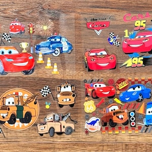 May include: Colorful stickers featuring characters from the Disney Pixar Cars movie. The stickers include images of race cars, Mater, Lightning McQueen, and other vehicles, along with racing flags, trophies, and the number 95.