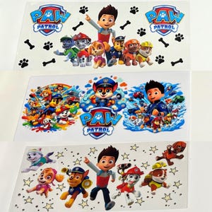 May include: Three sheets of Paw Patrol iron-on transfers. The first sheet features a group of Paw Patrol characters with Ryder in the center. The second sheet features a group of Paw Patrol characters with Chase and Marshall in the center. The third sheet features a group of Paw Patrol characters with Ryder in the center and stars in the background.