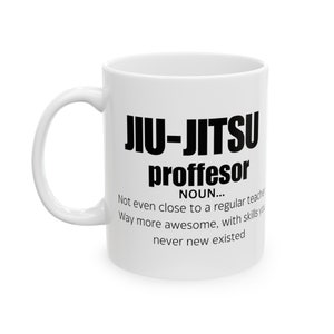 May include: White ceramic coffee mug with a black graphic that reads "JIU-JITSU proffesor NOUN... Not even close to a regular teacher Way more awesome, with skills you never new existed"