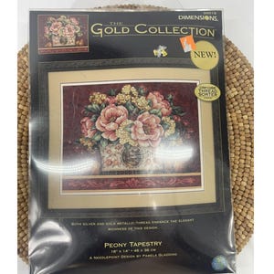 May include: A Dimensions Gold Collection Peony Tapestry needlepoint kit. The kit features a floral design with pink and white flowers in a decorative vase. The dimensions of the finished tapestry are 18 x 14 inches (46 x 36 cm).