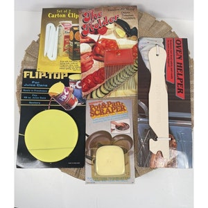 May include: A set of kitchen gadgets including a white oven helper, a yellow flip top for juice cans, a red and white pot and pan scraper, and a white carton clip. The packaging features images of the products and instructions for use.
