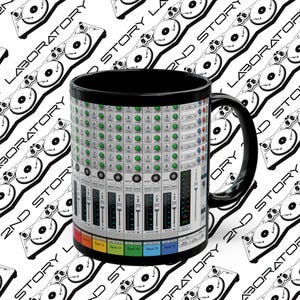 May include: Black ceramic mug with a white image of a soundboard with knobs and buttons. The text "Track 11", "Track 12", "Track 13", "Track 14", and "Track 15" are visible on the soundboard.