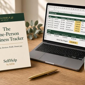 Könnte beinhalten: Ein Buch mit dem Titel The One-Person Business Tracker von SelfHelp by KElle, ein Laptop mit einer Rechnungs-Tabelle, ein goldener Stift und eine Keramiktasse. Das Buchcover ist in Dunkelgrün und Creme gehalten und enthält geschäftliche Texte.