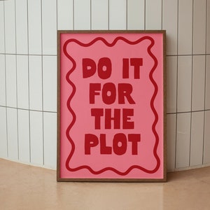 May include: A framed pink poster with a wavy border and the text "DO IT FOR THE PLOT" in red.