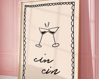 Peut inclure: Une impression encadrée avec une illustration en noir et blanc de deux verres à martini qui trinquent. Le texte "cin cin" est écrit sous les verres.