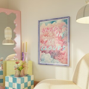 May include: A framed print with a pink and blue cloud background and the text "Head in the Clouds" in a light blue and pink font.