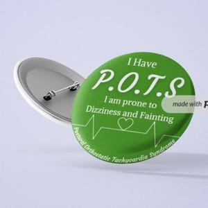 Puede incluir: Botón verde con texto blanco que dice "I Have P.O.T.S I am prone to Dizziness and Fainting" con un corazón y una línea de ECG. El texto "Postural Orthostatic Tachycardia Syndrome" está escrito en una fuente más pequeña en la parte inferior del botón. El botón está hecho con Placeit.