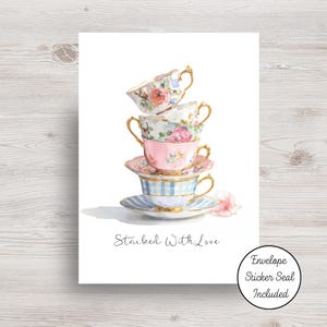 May include: A white ceramic mug with a black handle and the text "But First, Coffee" in a bold, black font. The mug is set against a blurred background, suggesting a cozy setting. The mug appears to be approximately 4 inches tall.