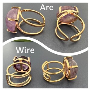 May include: Two gold rings with a purple amethyst stone. The rings are shown from different angles, with the text "Arc" and "Wire" above them.