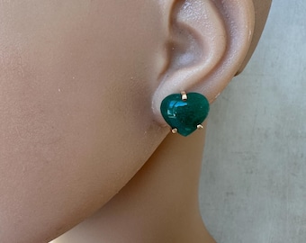 May include: A pair of gold heart-shaped earrings with green gemstone accents.