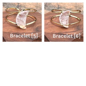 May include: Two gold bracelets with a crescent moon shaped clear quartz stone. The bracelets are on a wooden surface. The text "Bracelet [5]" and "Bracelet [6]" is below each bracelet.