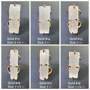 May include: Six gold-toned rings featuring rectangular, translucent white selenite crystals held by four prongs. Each ring is labelled with a number from 13 to 18 and a corresponding US ring size ranging from 6 1/2 to 7 1/2.