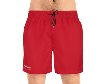 Könnte beinhalten: Rote Badehose mit einem gestickten Flugzeug und dem Text "Royal Trainer" am linken Bein.