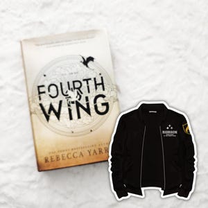 Può includere: Un libro intitolato "Fourth Wing" di Rebecca Yarros, con un'illustrazione in bianco e nero di un drago sulla copertina. Una giacca bomber nera con una toppa dorata che dice "Riordian" è sul lato destro dell'immagine.