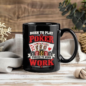 May include: A black ceramic mug featuring a graphic print with the text BORN TO PLAY POKER FORCED TO WORK. The design includes a row of five playing cards showing a royal flush in hearts and a stack of colourful poker chips in the centre.