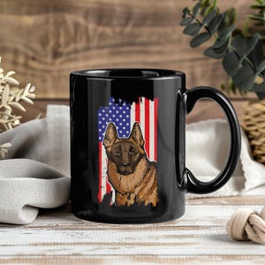 Può includere: Tazza in ceramica nera con un'illustrazione di un pastore tedesco e un design della bandiera americana. Il cane è marrone e marrone chiaro, su uno sfondo della bandiera americana usurata. La tazza ha un manico nero ed è adatta per bevande calde o fredde.