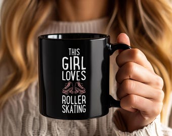 May include: Black ceramic mug with the text "THIS GIRL LOVES ROLLER SKATING" in white and pink. The mug features a graphic of pink roller skates. The mug has a black handle and is held by a person.